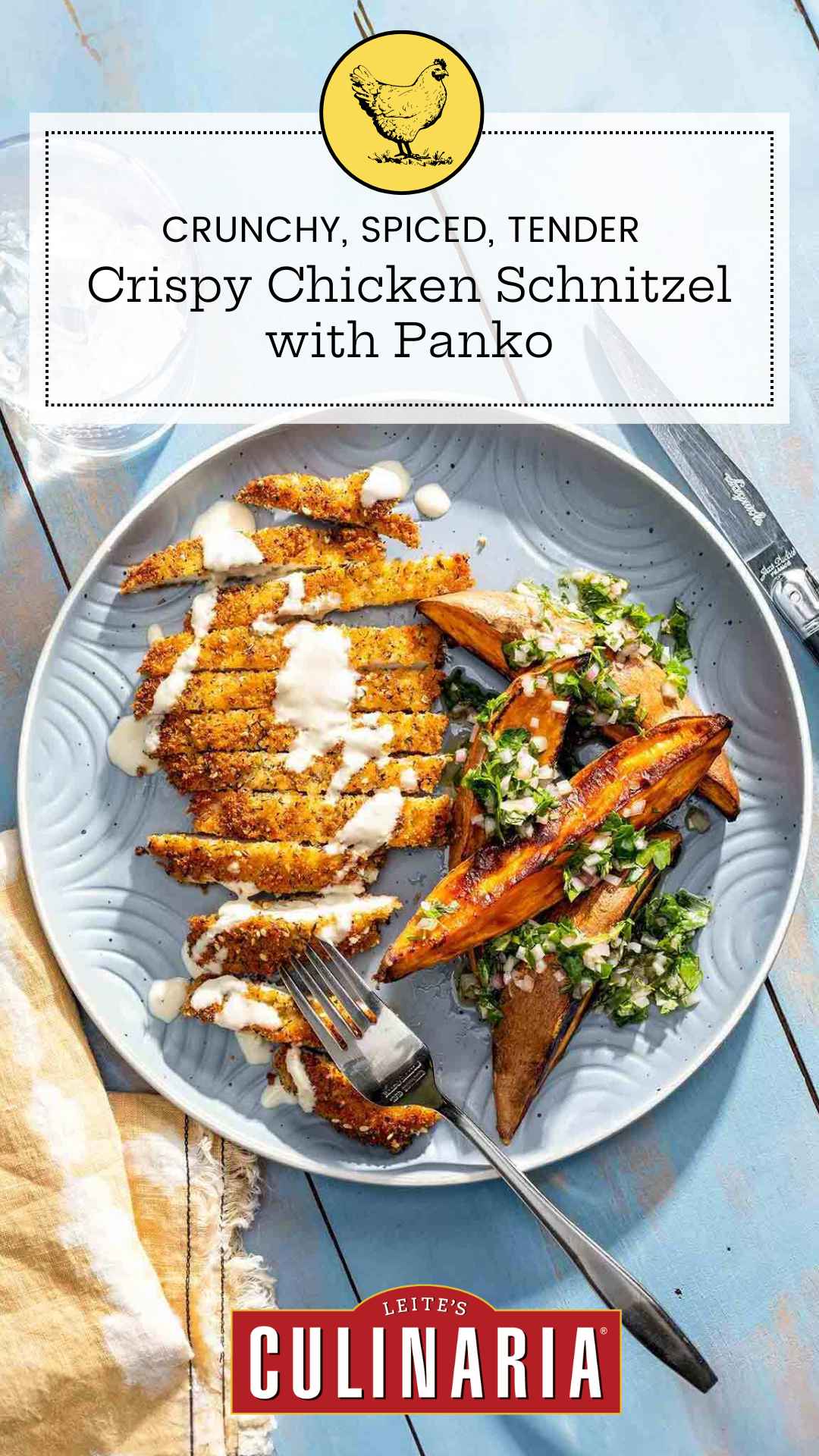 A sliced chicken cutlet with panko coating on a plate with sweet potato wedges and a vinaigrette dressing.