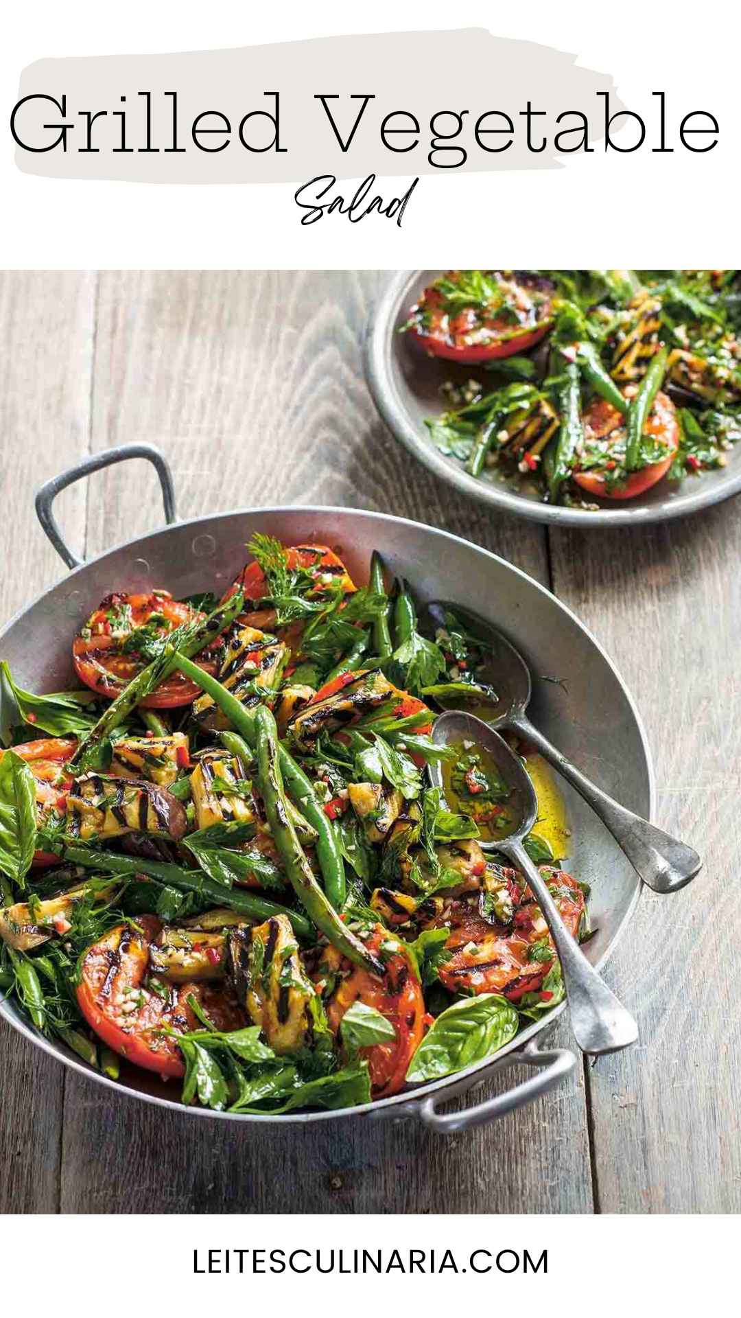 A large metal bowl filled with grilled zucchini, beans, tomatoes, and fresh basil.