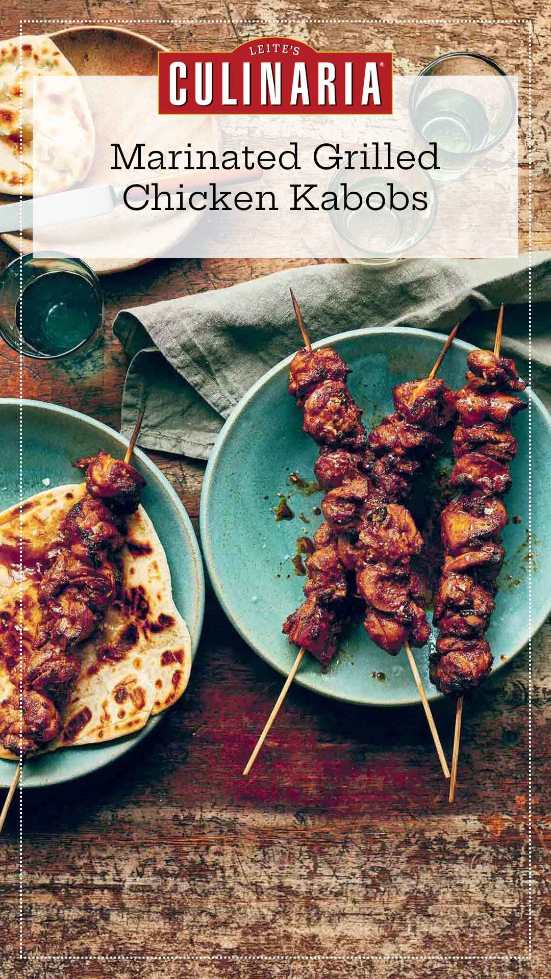 Three marinated chicken skewers on a blue plate with another skewer on top of a flatbread on a second plate.