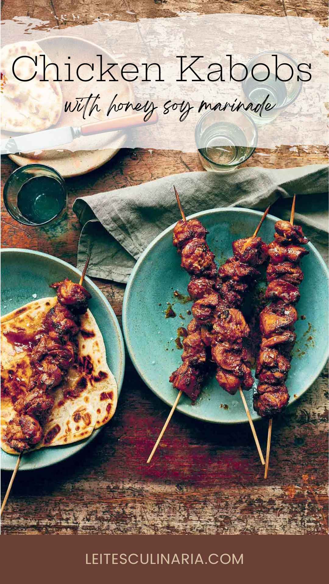 Three marinated chicken skewers on a blue plate with another skewer on top of a flatbread on a second plate.