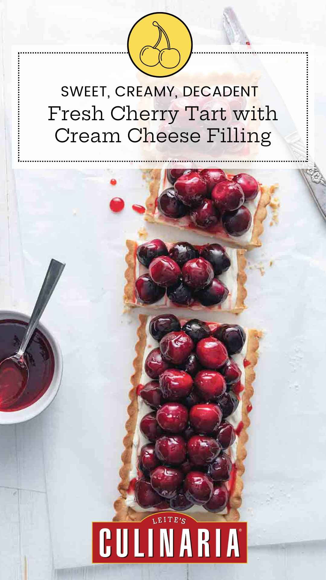 A rectangular tart filled with cream cheese filling and topped with fresh cherries cut into several pieces.