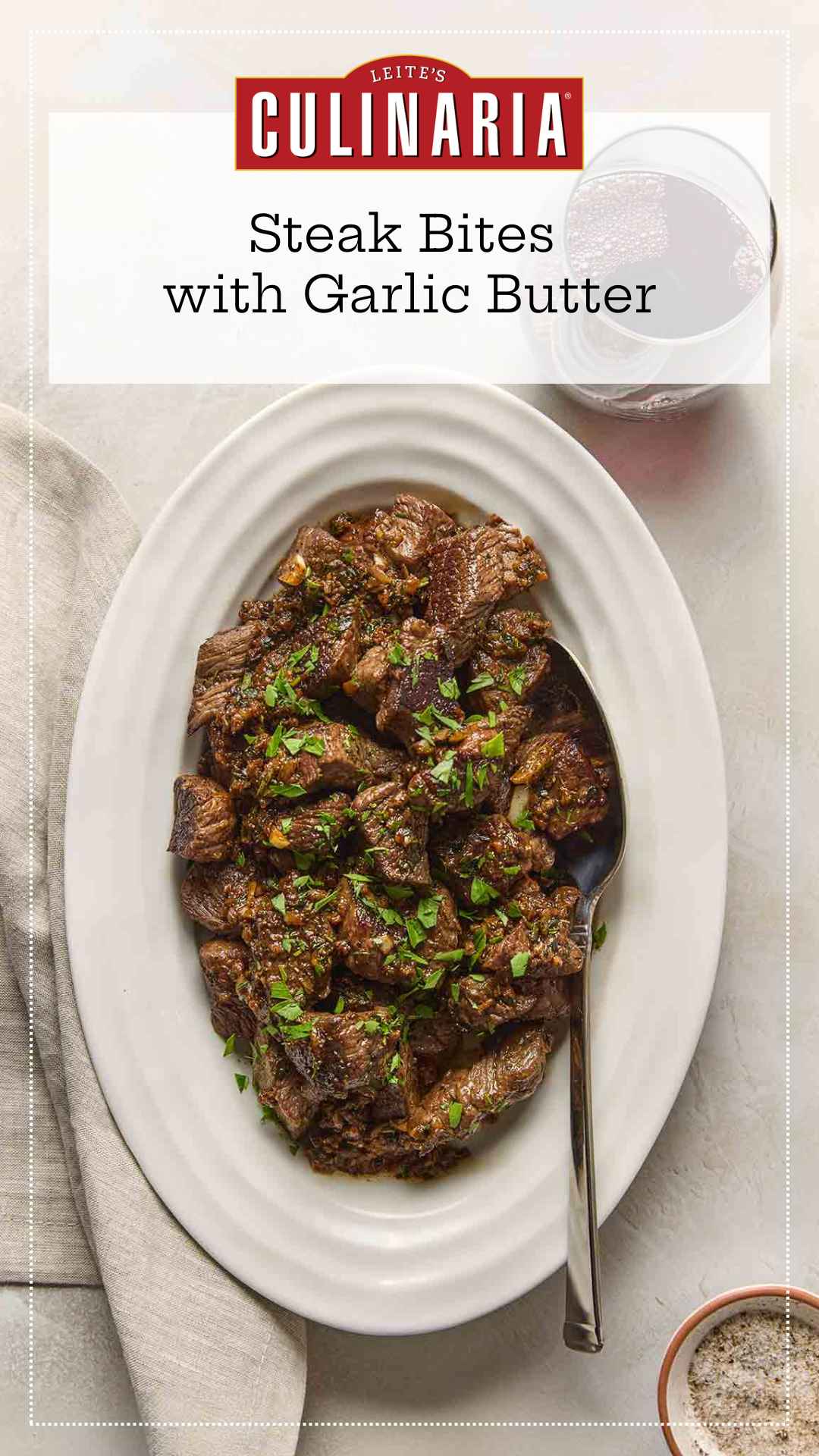 An oval platter of garlic butter steak bites, garnished with fresh parsley.