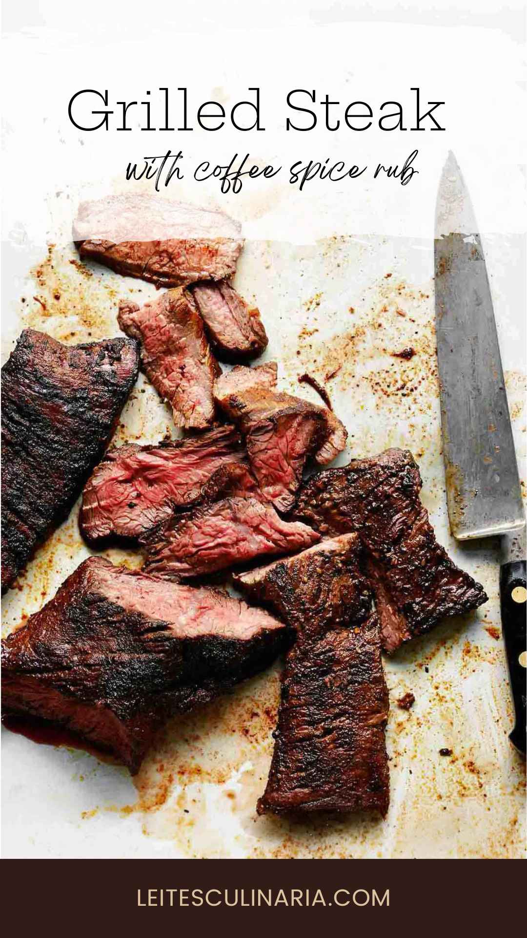 A grilled skirt steak sliced into pieces with a chef's knife on the side.