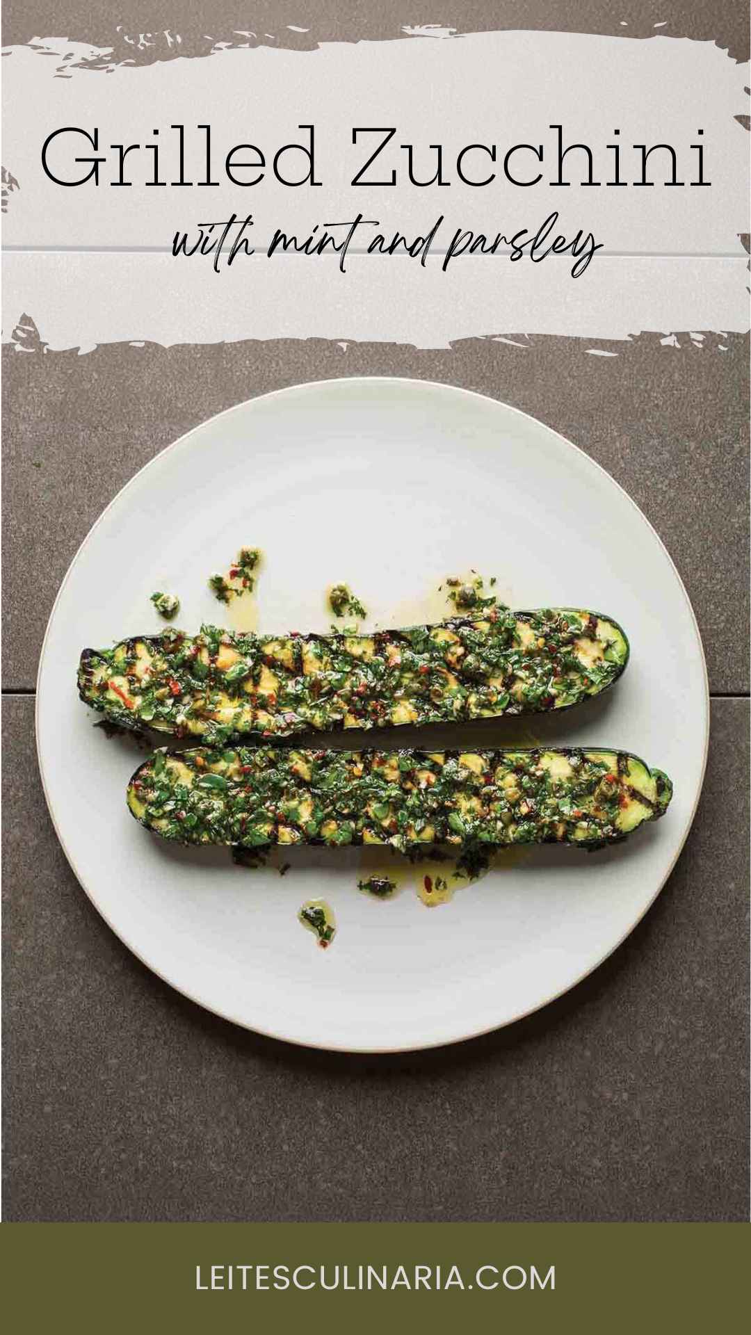 Two grilled zucchini halves topped with mint salsa on a white plate.