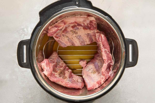 Three slabs of ribs on a rack inside an Instant Pot.