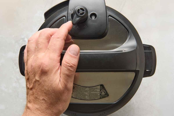 A person setting an Instant Pot.