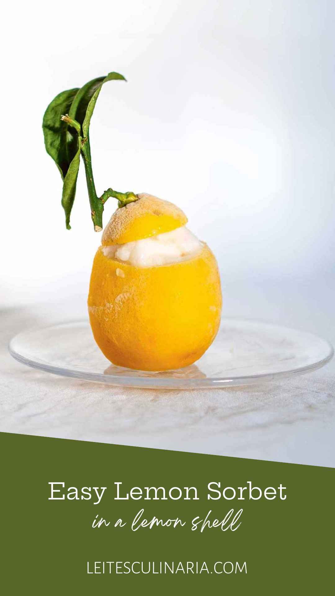 A whole lemon filled with lemon sorbet with the lemon top and leaf resting on top.