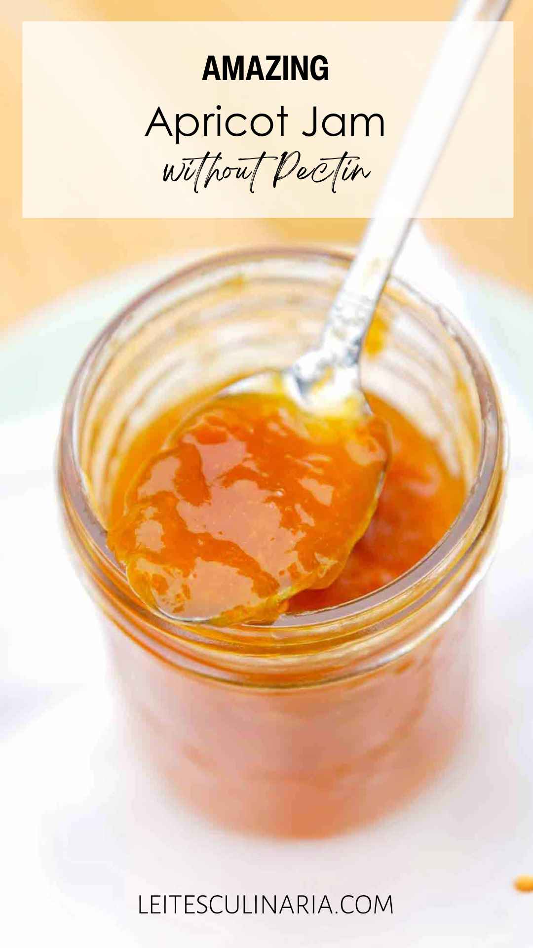 A jar of apricot jam with a spoonful of jam resting on top.