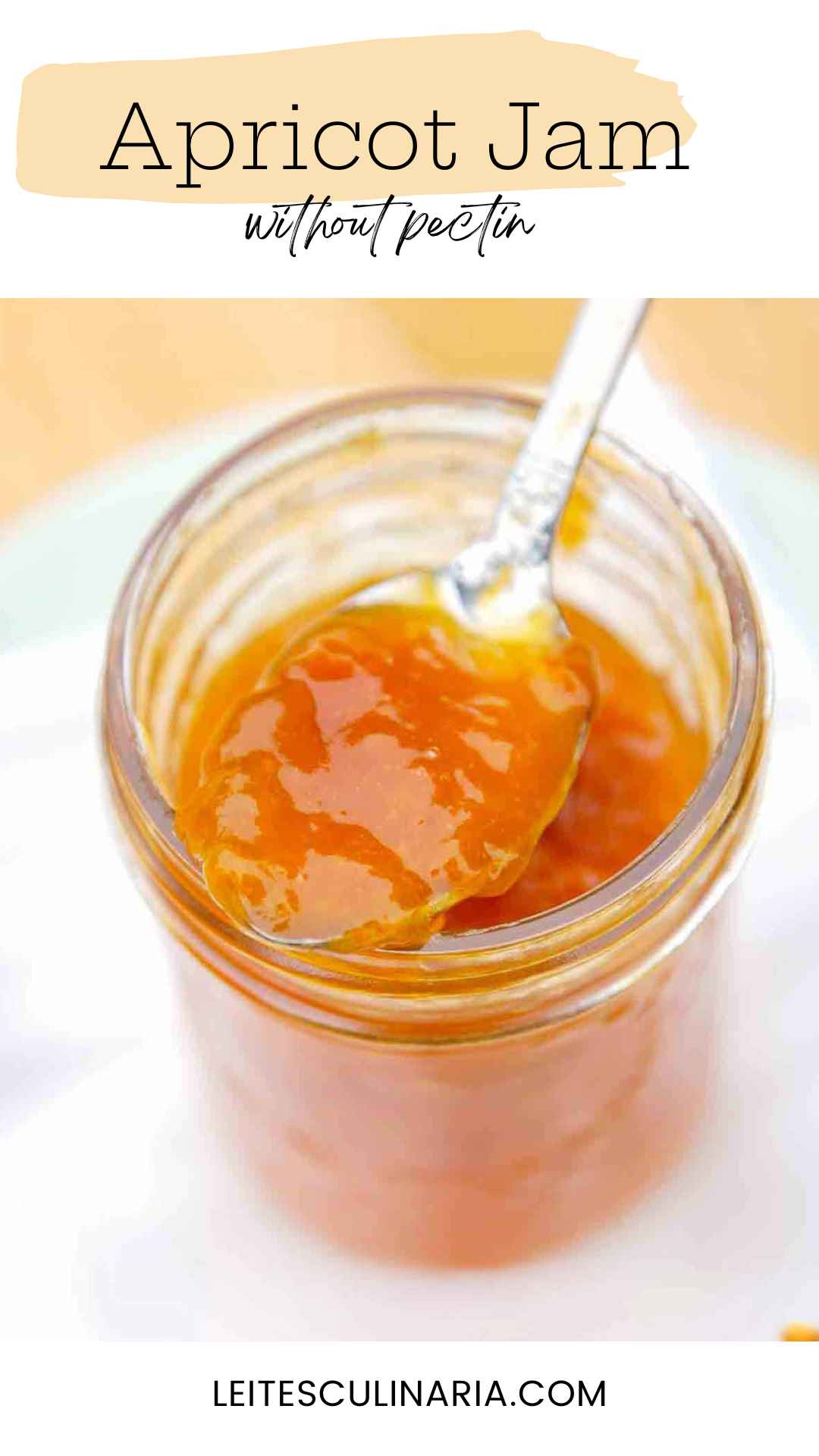 A jar of apricot jam with a spoonful of jam resting on top.
