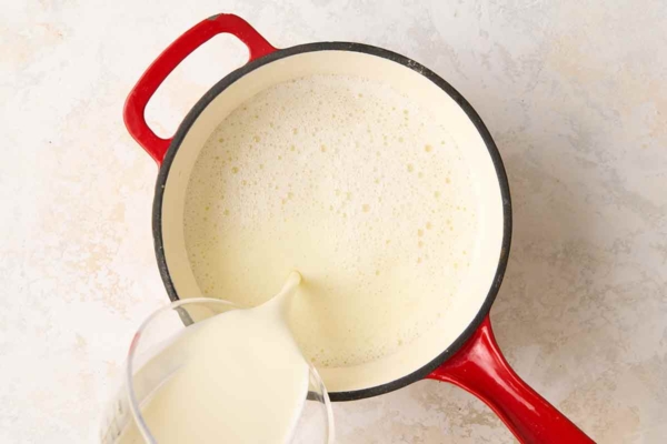 Milk being poured into a saucepan.