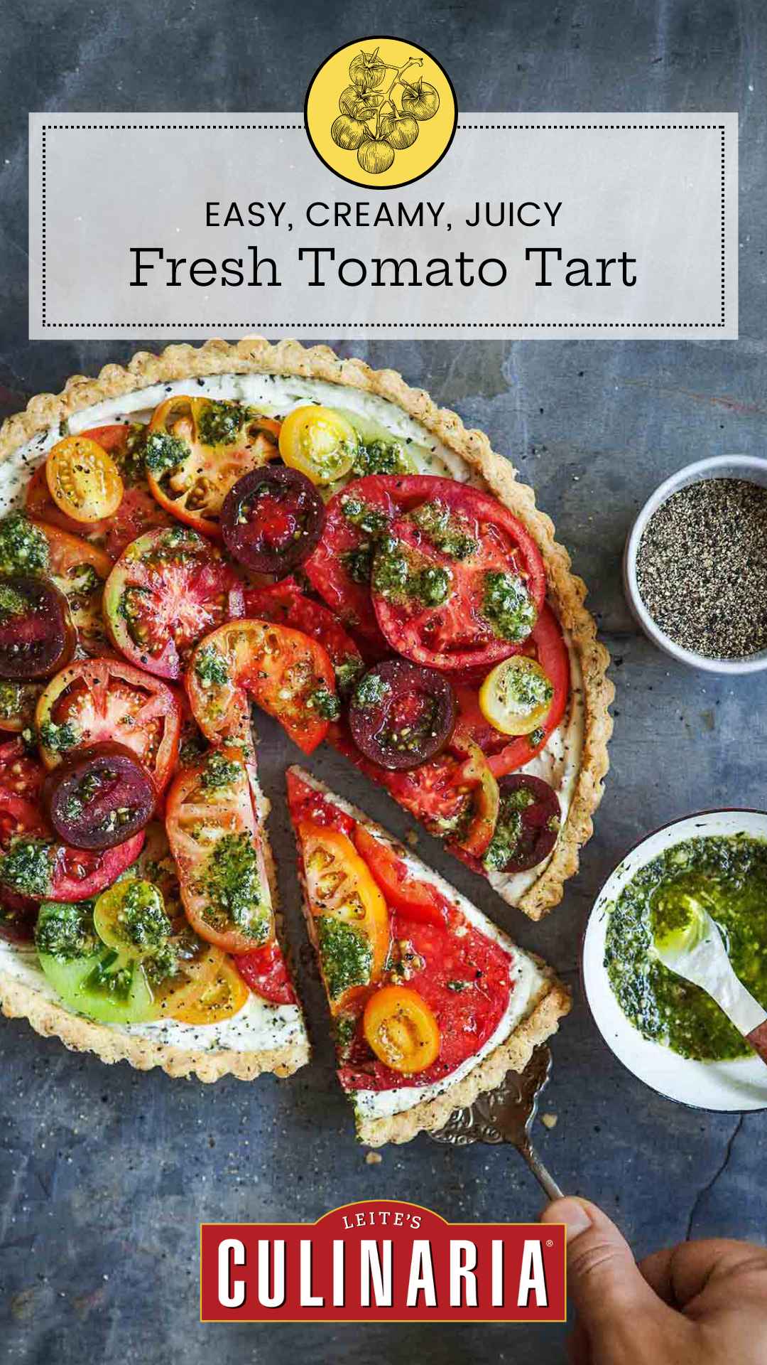 A whole tomato tart with one slice being removed from it and a bowl of pesto sauce on the side.