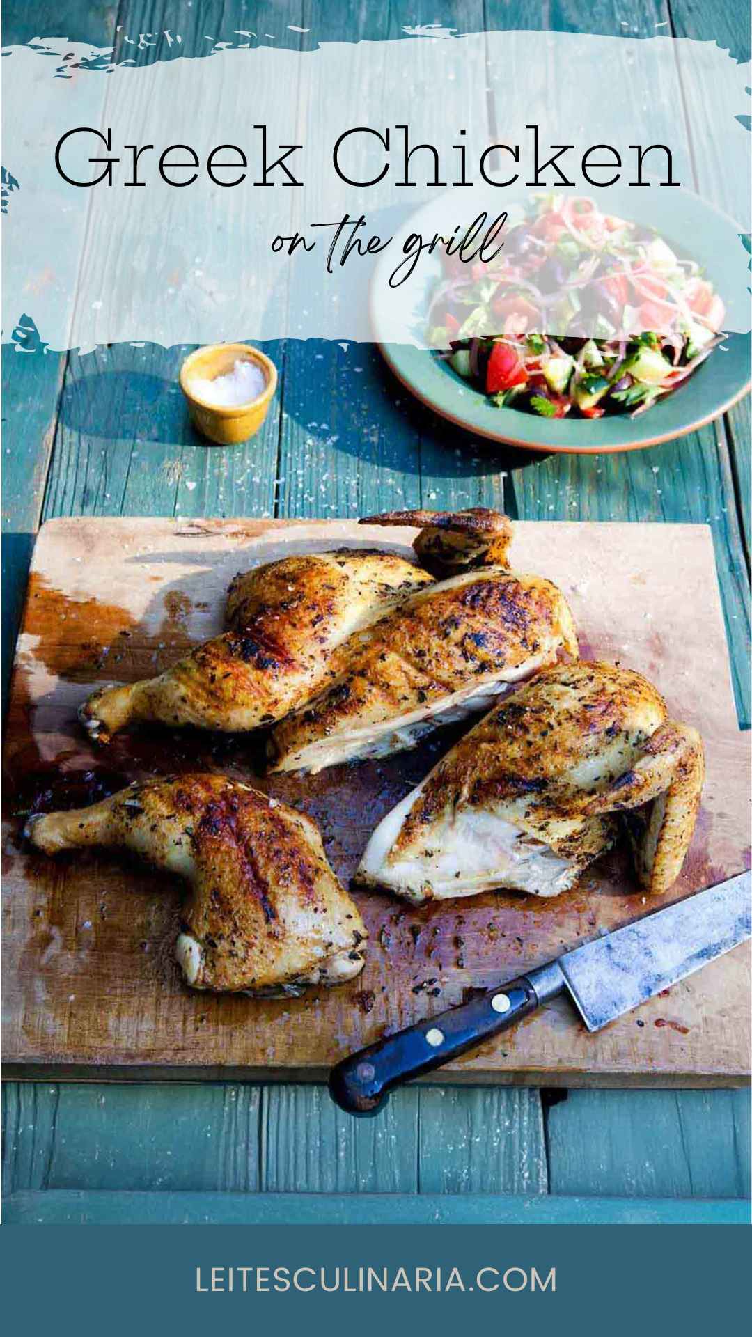 A partially carved grilled marinated chicken on a wooden board with a Greek salad nearby.