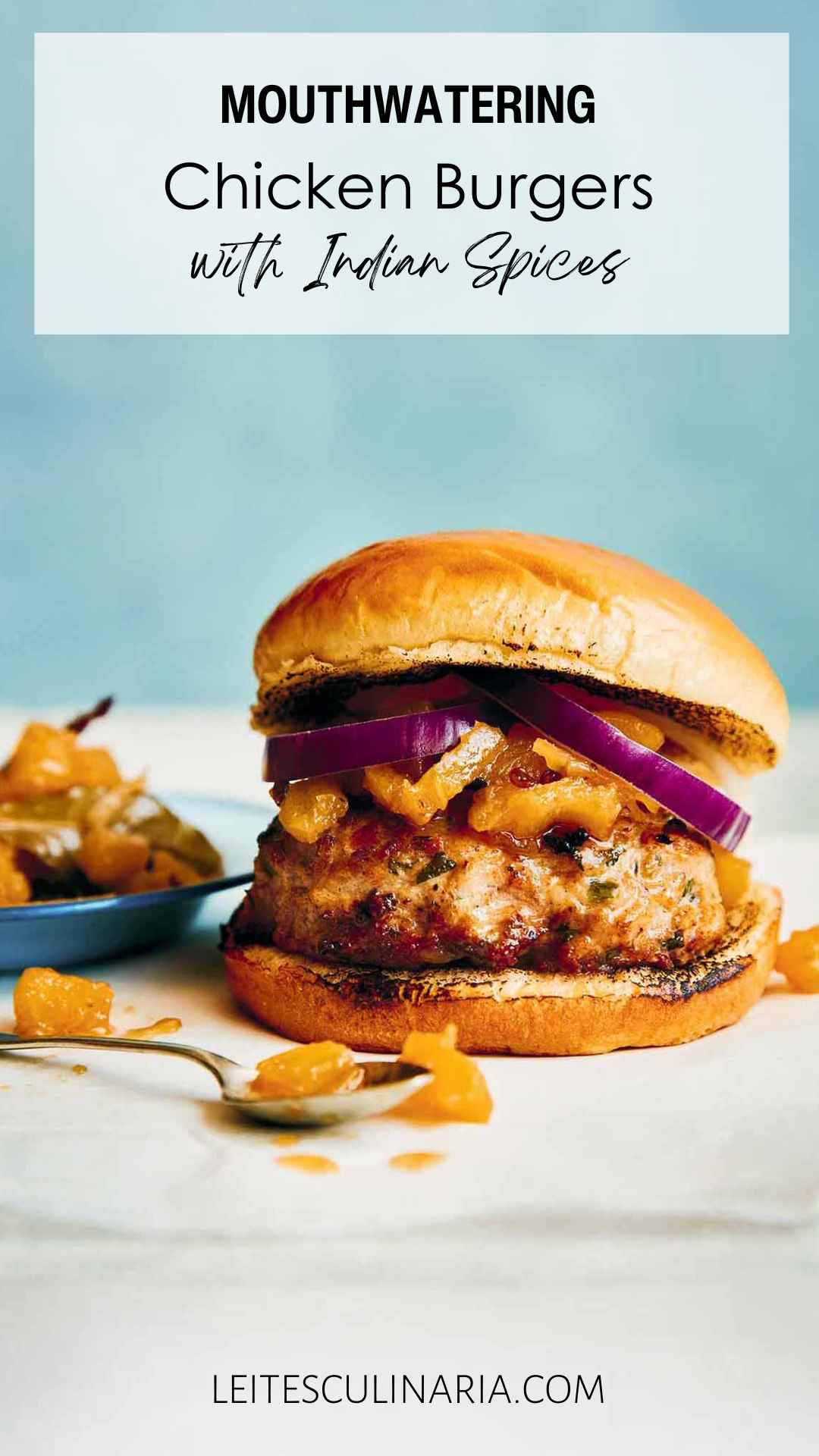 A ground chicken burger topped with red onion and chutney.