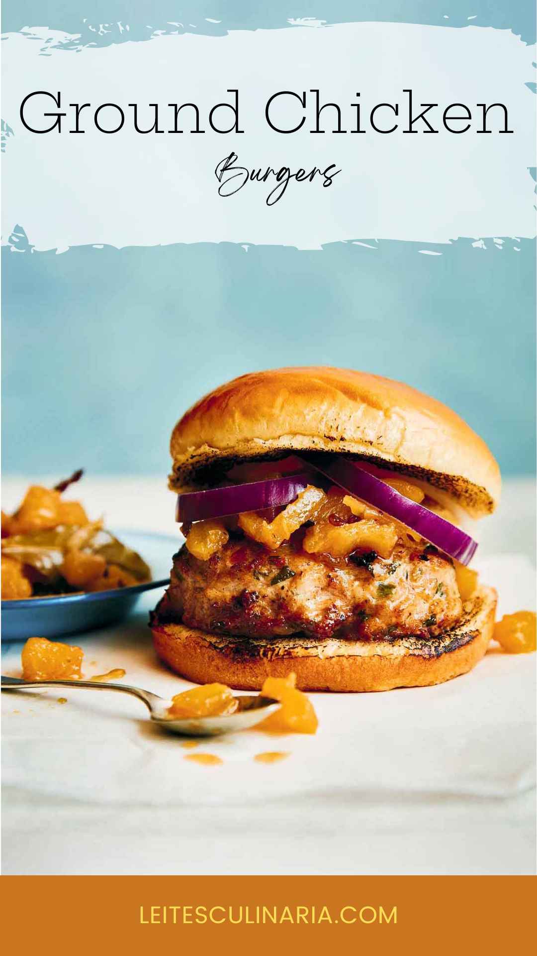 A ground chicken burger topped with red onion and chutney.