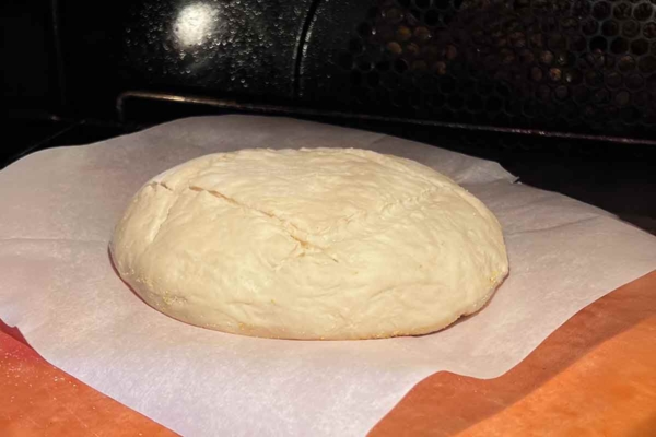 A round loaf of bread dough inside the oven.