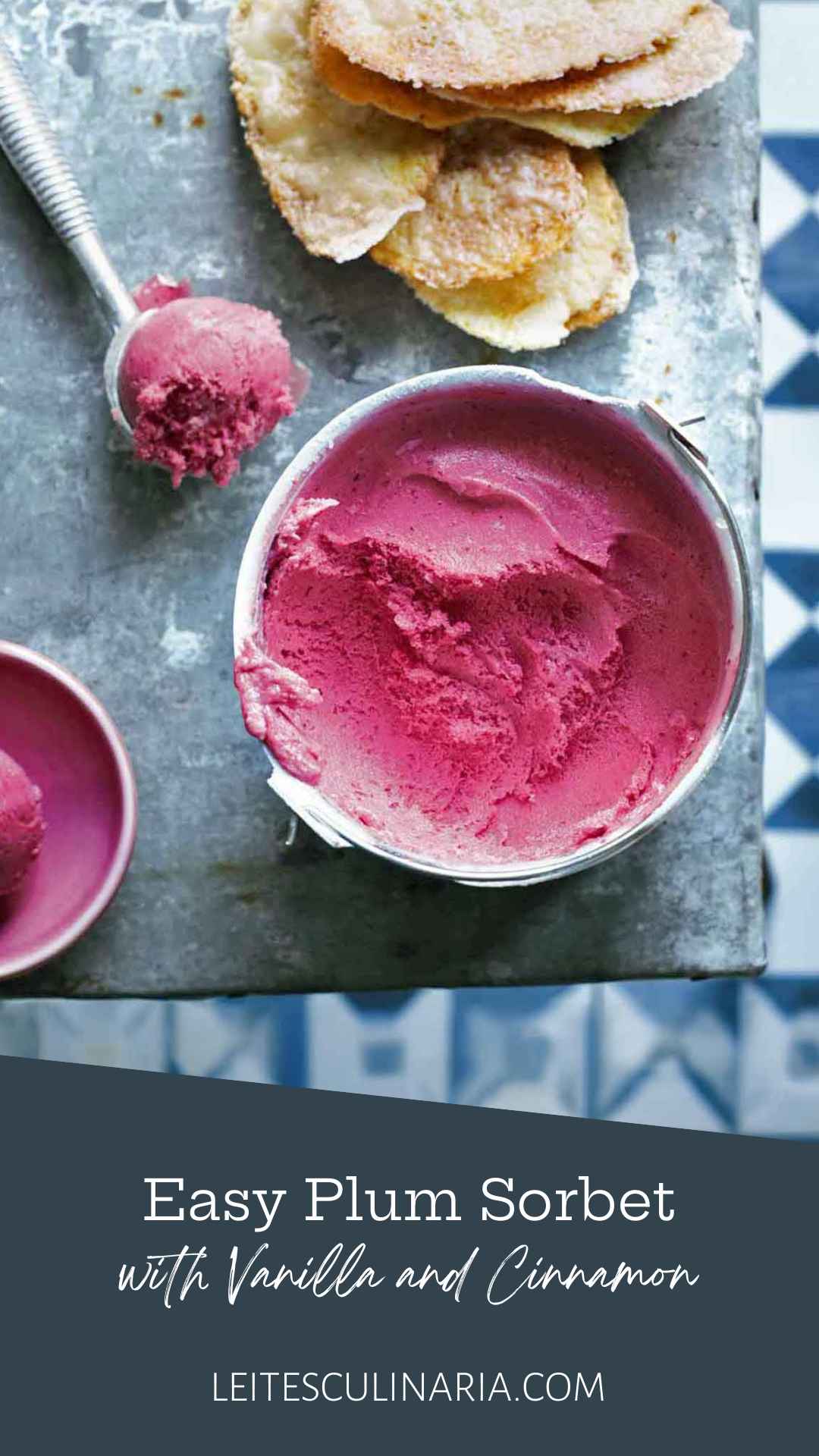 A small bucket of plum sorbet with a scoop of sorbet in a metal ice cream scoop nearby.