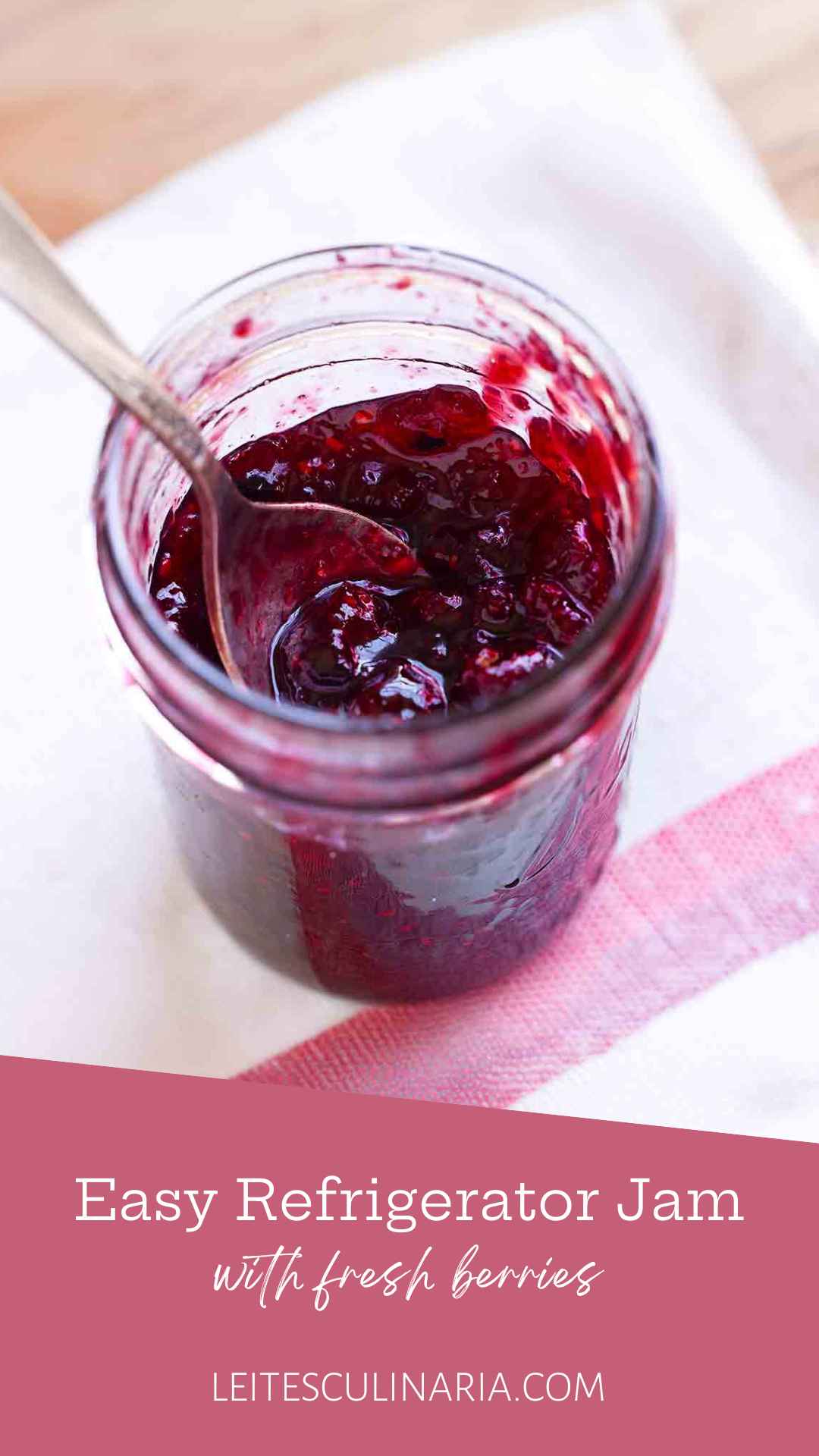 An open jar of homemade refrigerator jam with a spoon resting inside it.