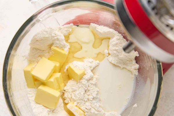 Butter, flour, oil, and milk in a glass mixing bowl.