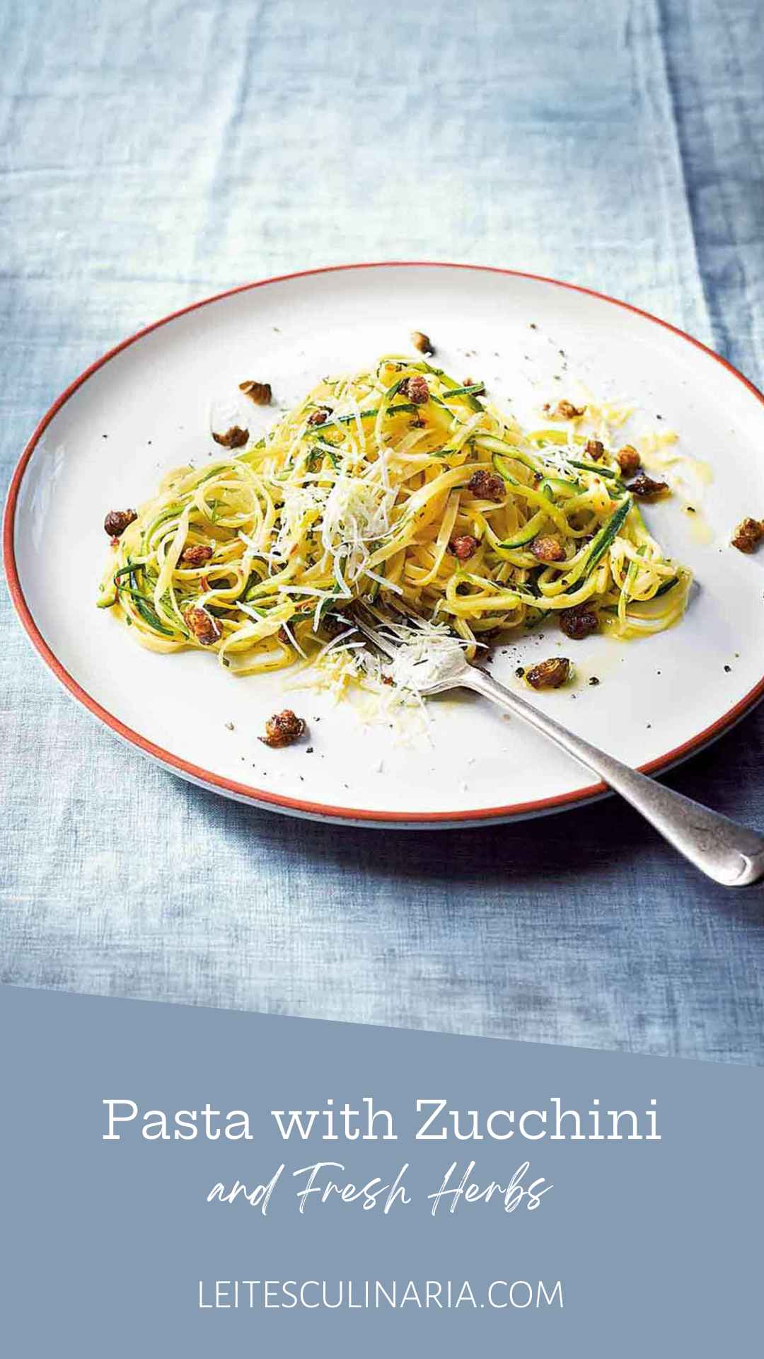 A serving of linguine and spiralized zucchini on a plate with capers and parmesan cheese.
