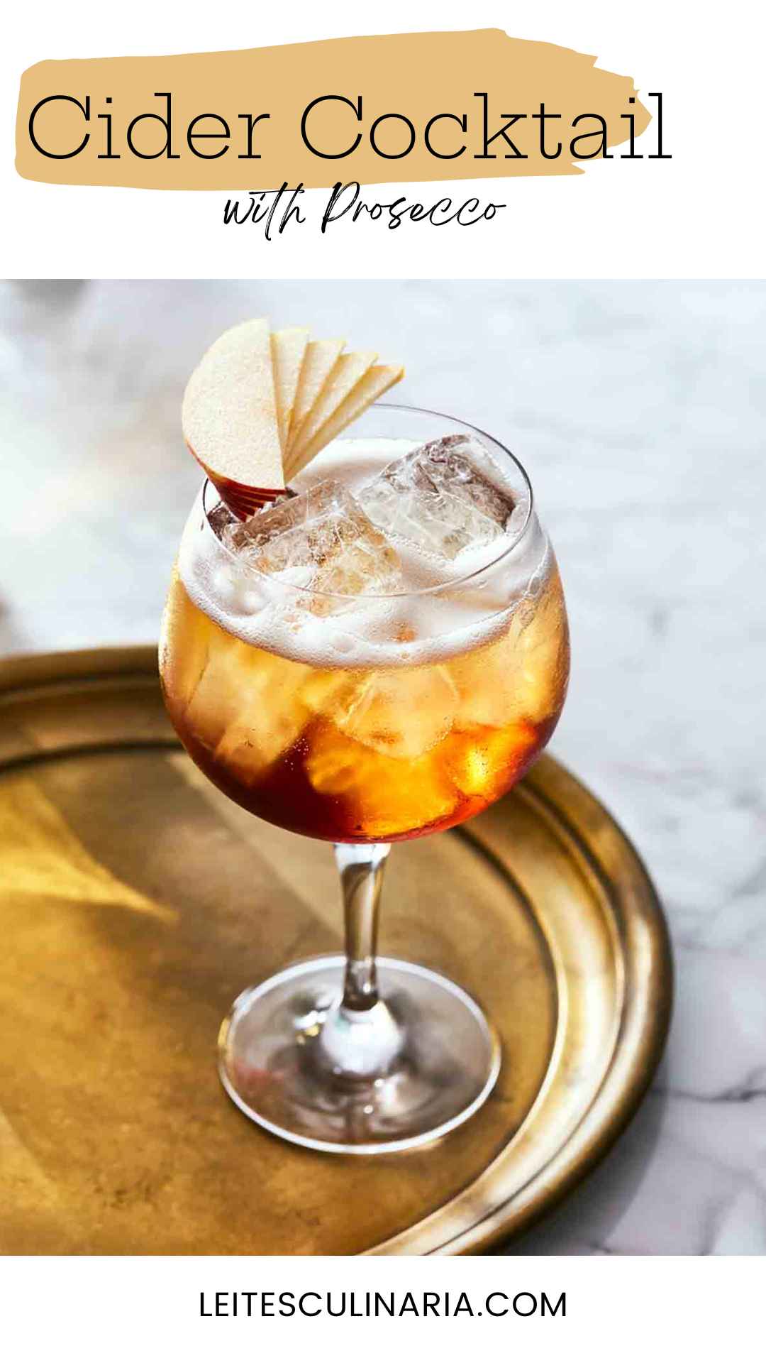 A wine glass filled with a fizzy cocktail and ice cubes, topped with apple slices.