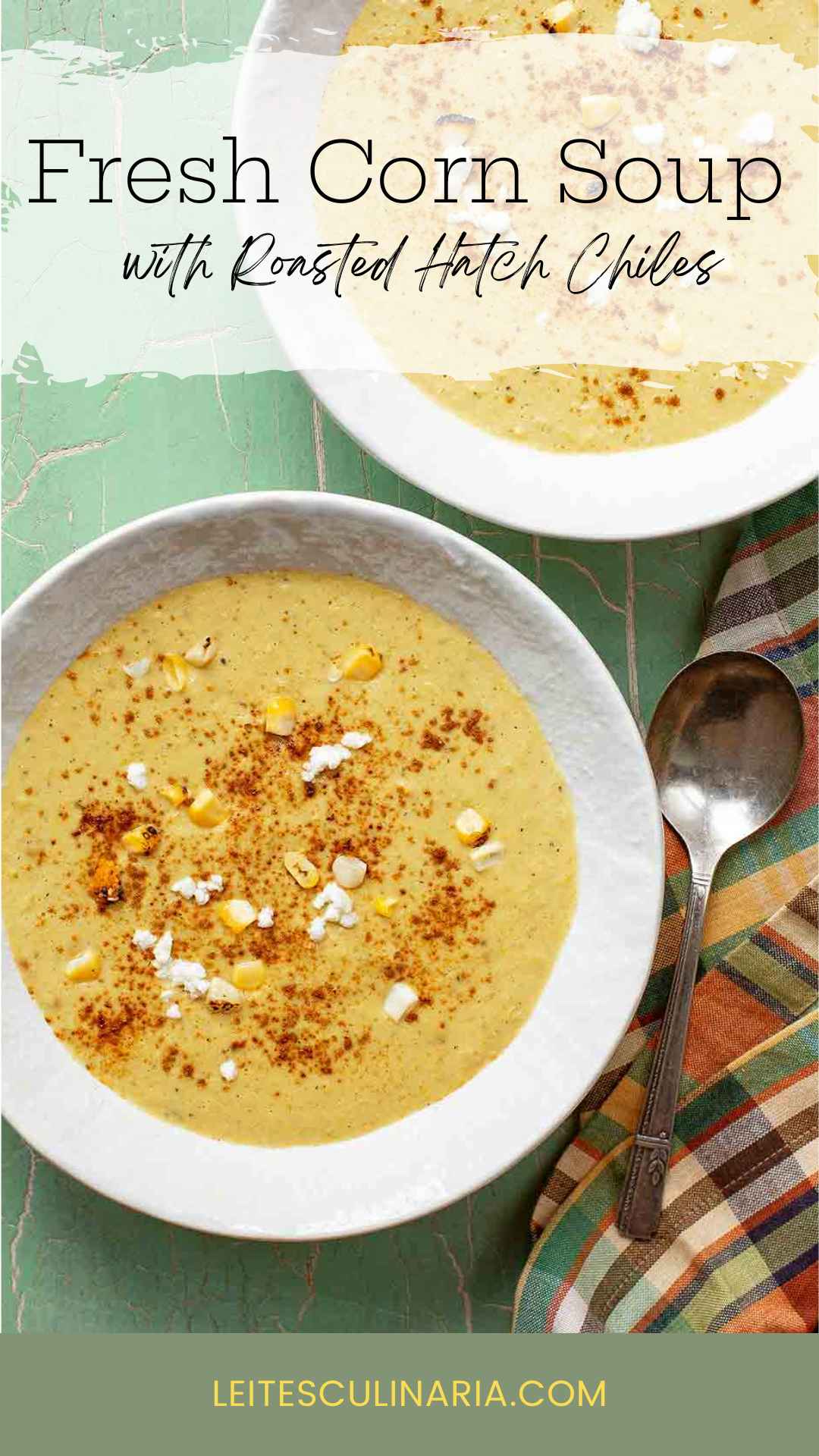 Two bowls of corn soup with fresh corn kernels, goat cheese, and paprika on top.