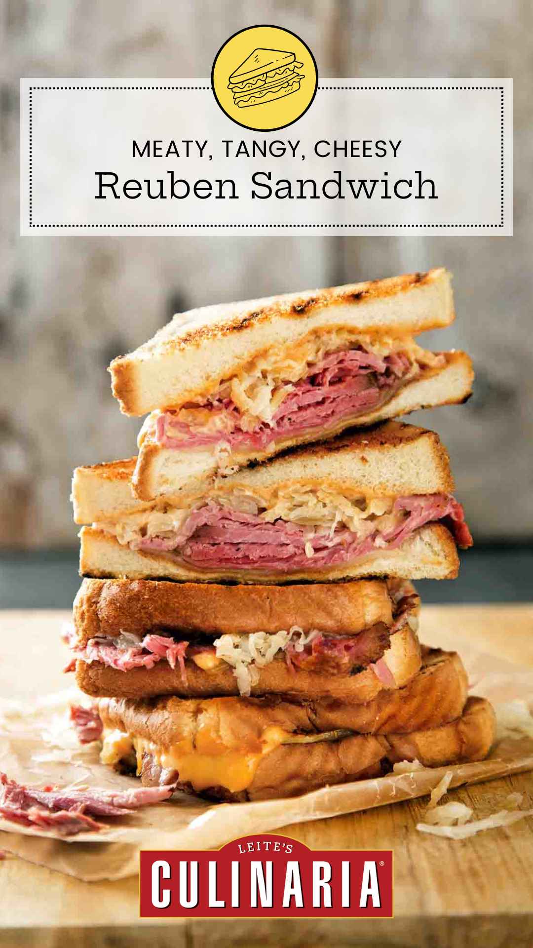 Quartered sections of a reuben sandwich stacked on top of each other on a wooden cutting board.