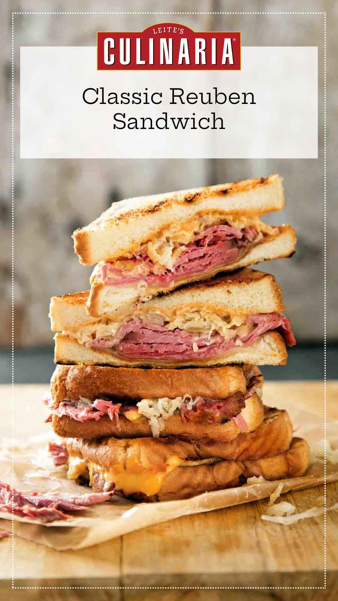 Quartered sections of a reuben sandwich stacked on top of each other on a wooden cutting board.