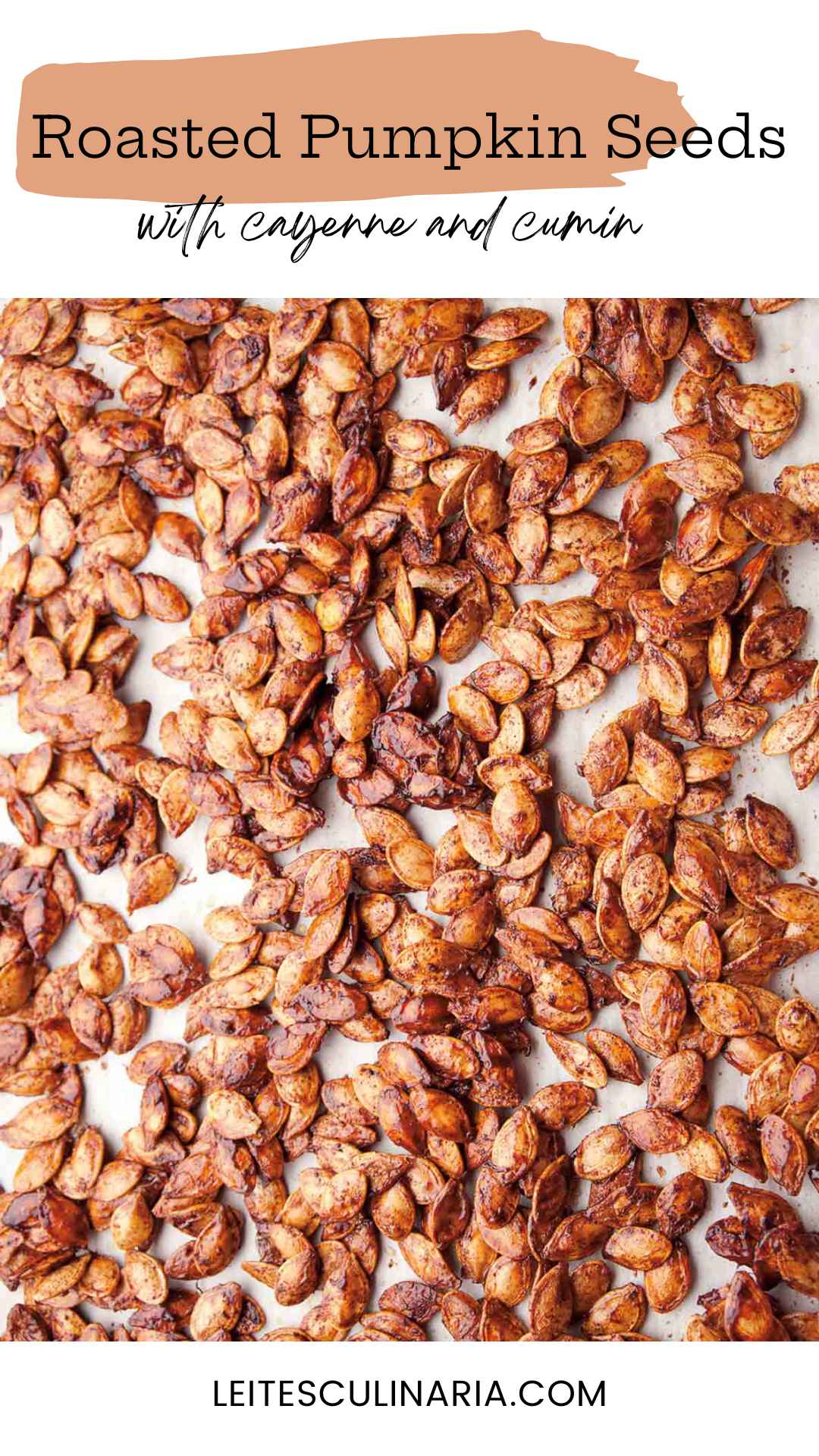 Pumpkin seeds, roasted with spices, spread on a white surface.