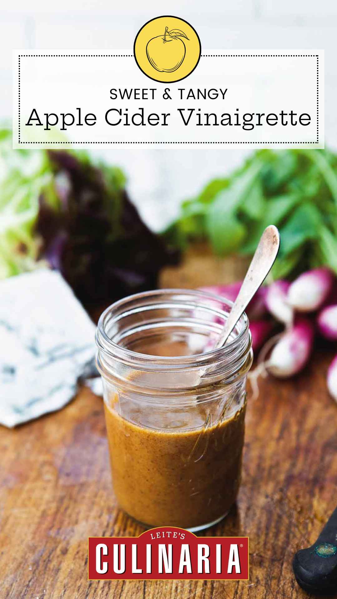 Small canning jar with spoon standing inside filled with apple cider vinaigrette.