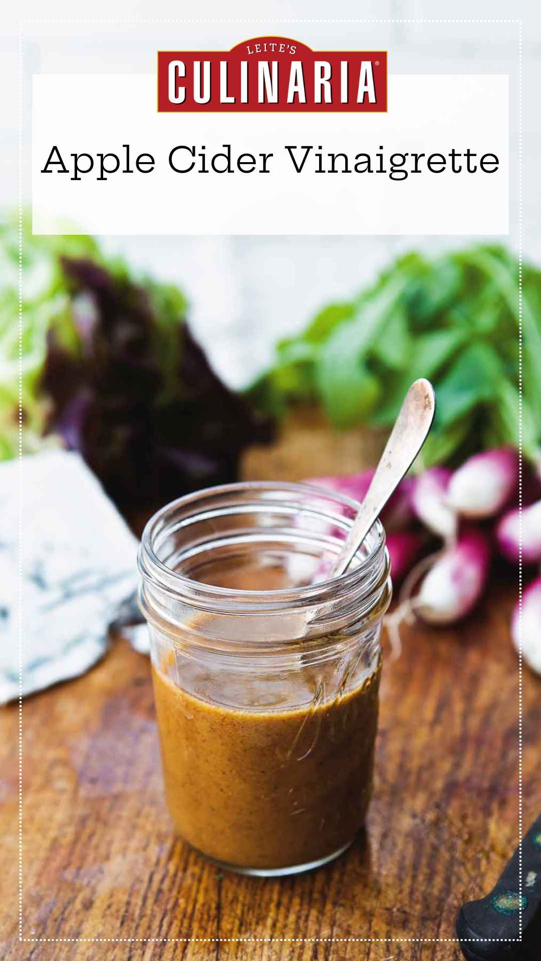 Small canning jar with spoon standing inside filled with apple cider vinaigrette.