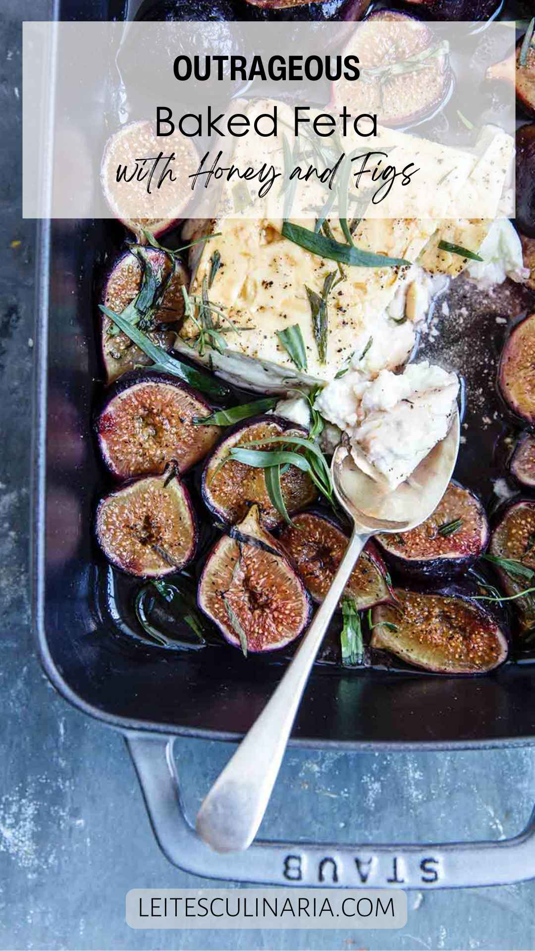 A rectangular baking dish filled with baked feta and figs, topped with fresh tarragon leaves.