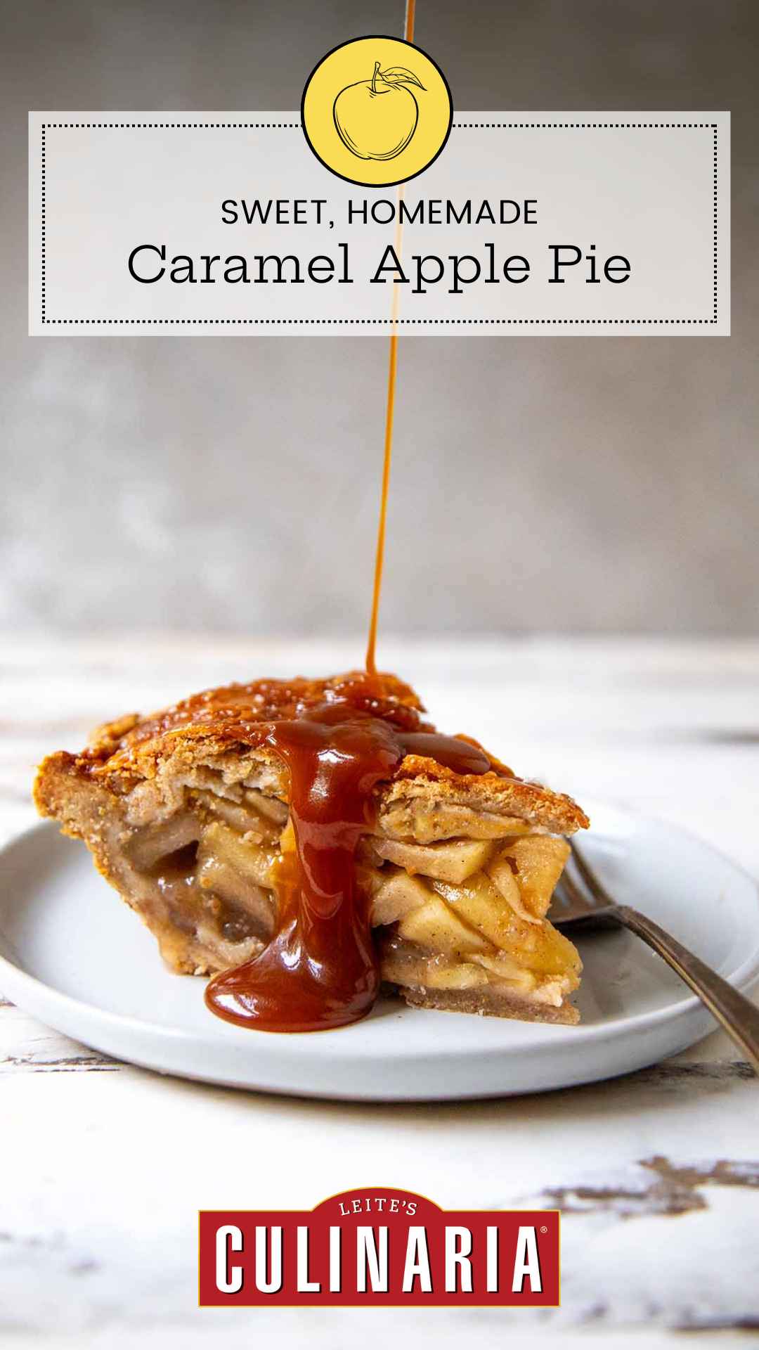 A slice of homemade caramel apple pie on a white plate. A thin stream of homemade caramel is drizzling over the top crust of the pie. A fork sits on the right next to the pie.