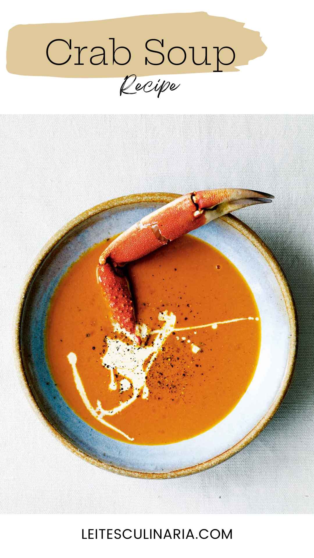 A bowl of crab soup, drizzled with cream, and sprinkled with pepper, with a crab leg sticking out of it.