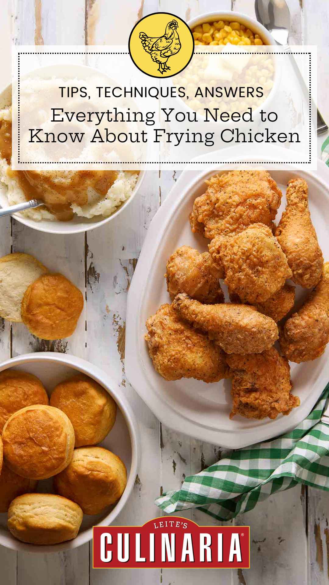 A platter of fried chicken with mashed potatoes, corn, and biscuits nearby.