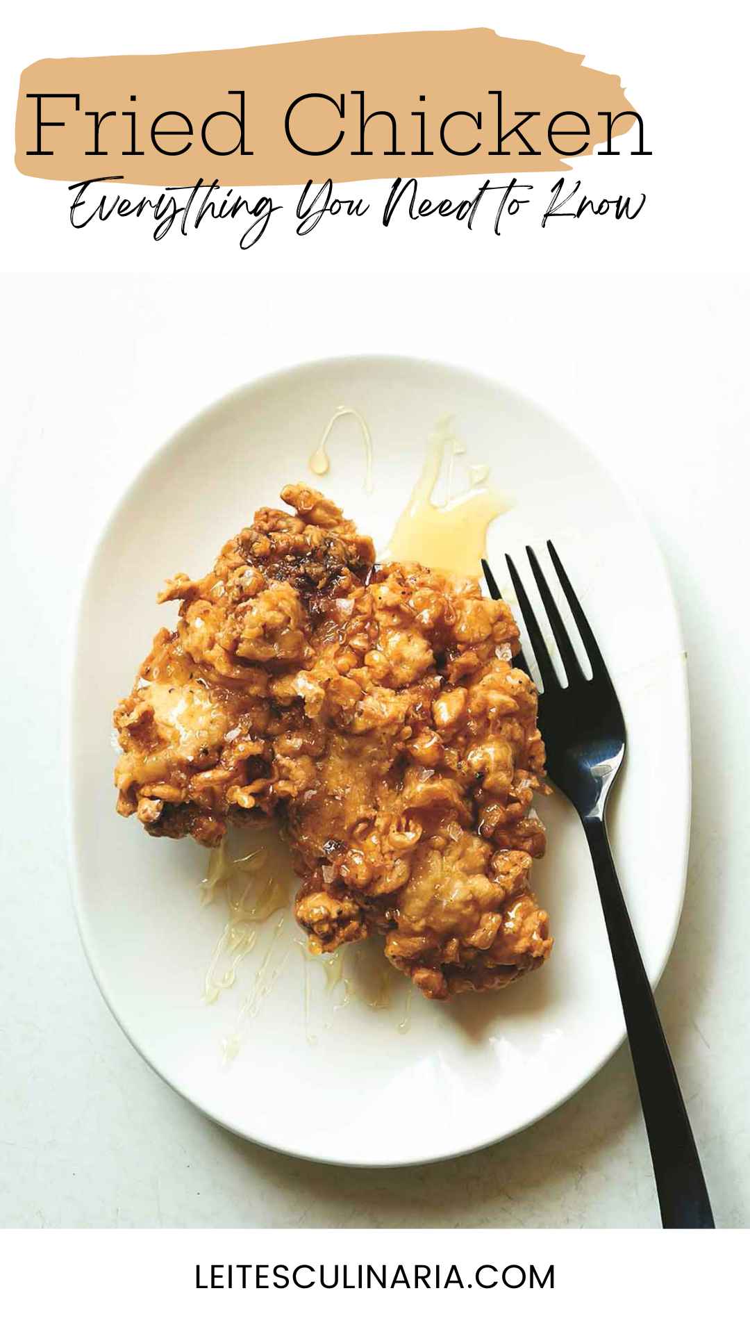 A crispy fried boneless chicken thigh drizzled with honey on a plate with a fork on the side.