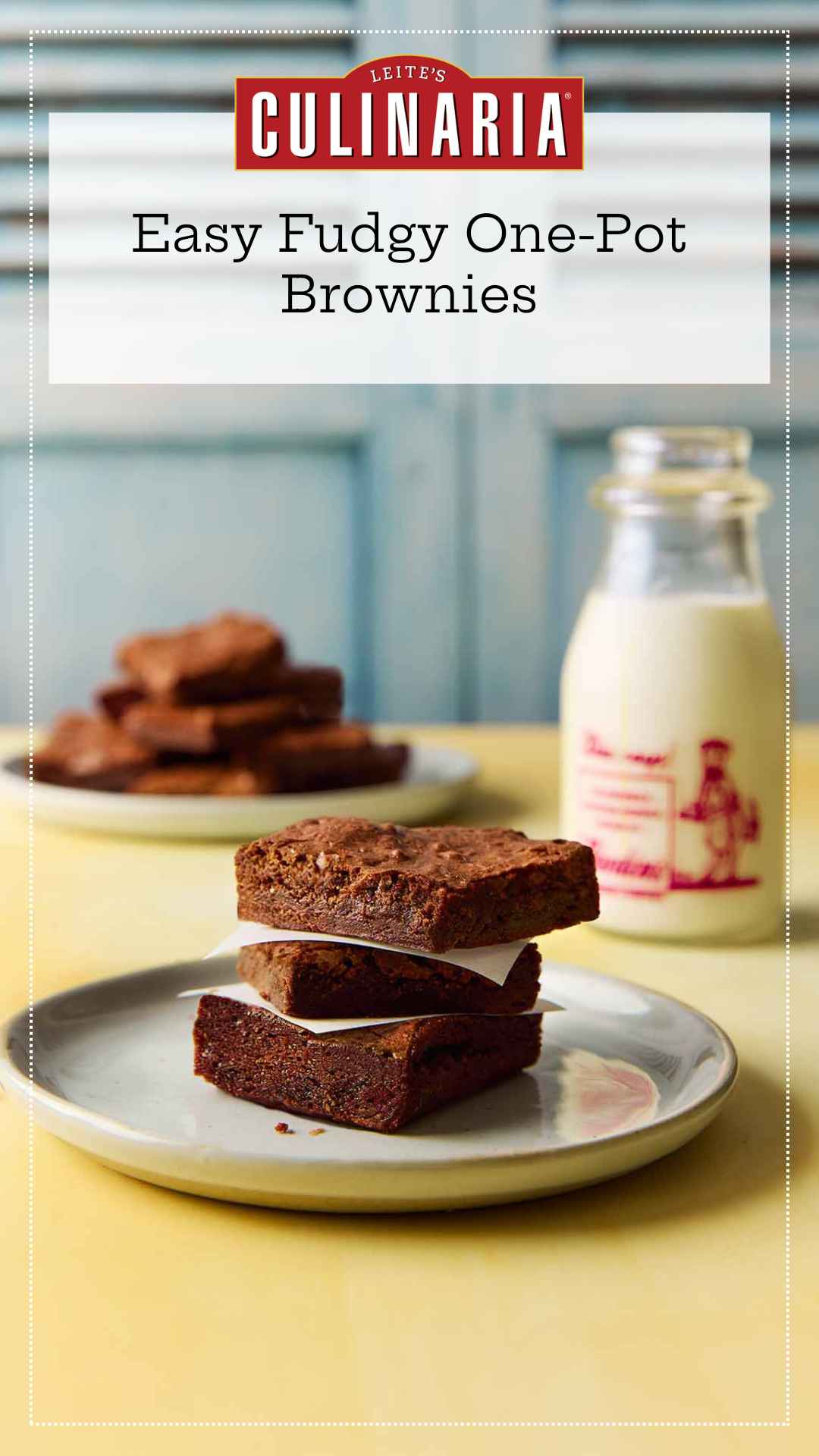 Three brownies stacked on a plate with a bottle of milk in the background.