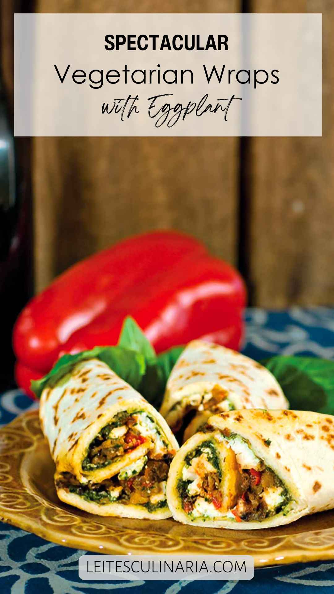 Three Mediterranean eggplant wraps on a plate with a whole red pepper in the background.