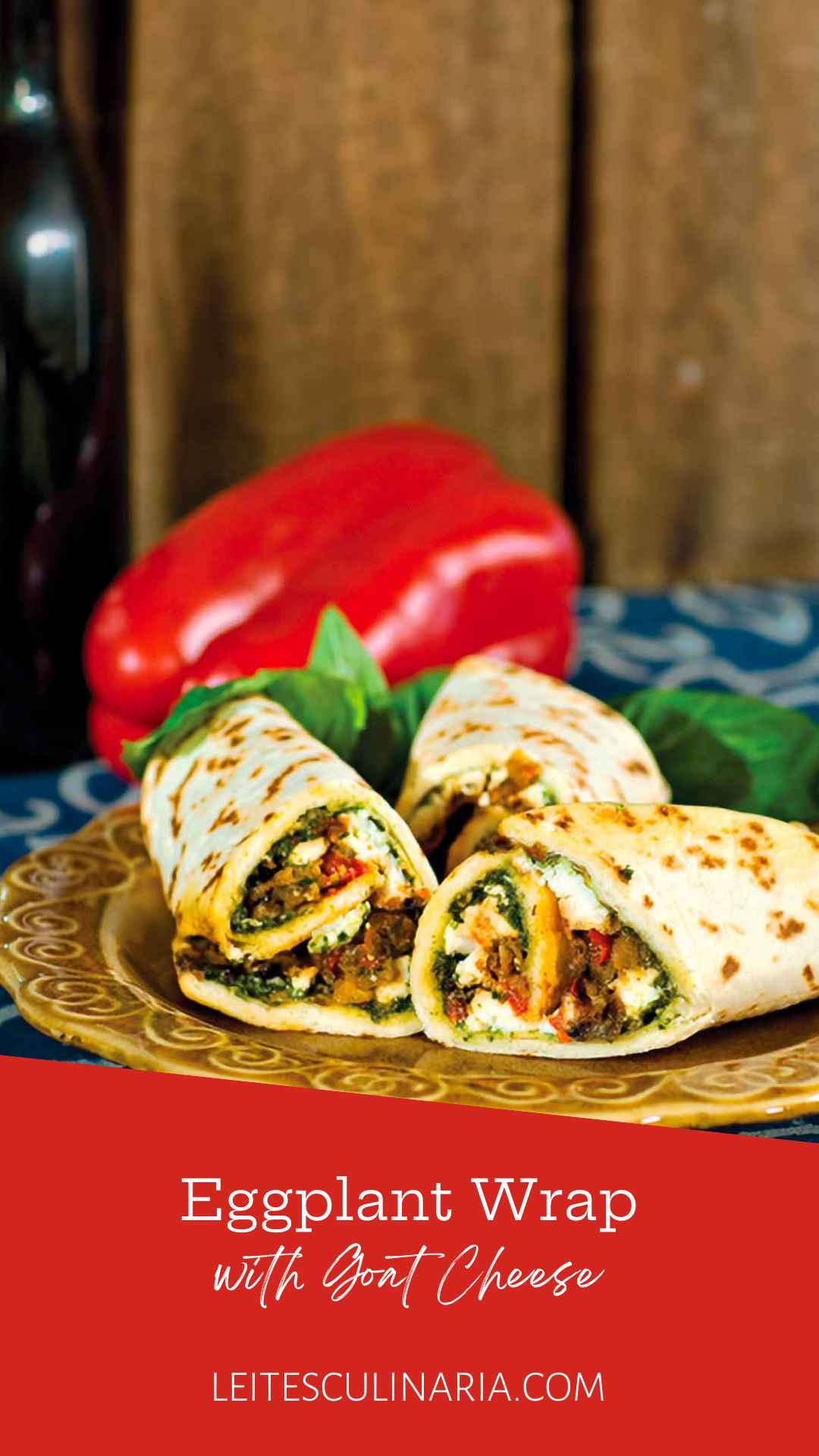 Three Mediterranean eggplant wraps on a plate with a whole red pepper in the background.