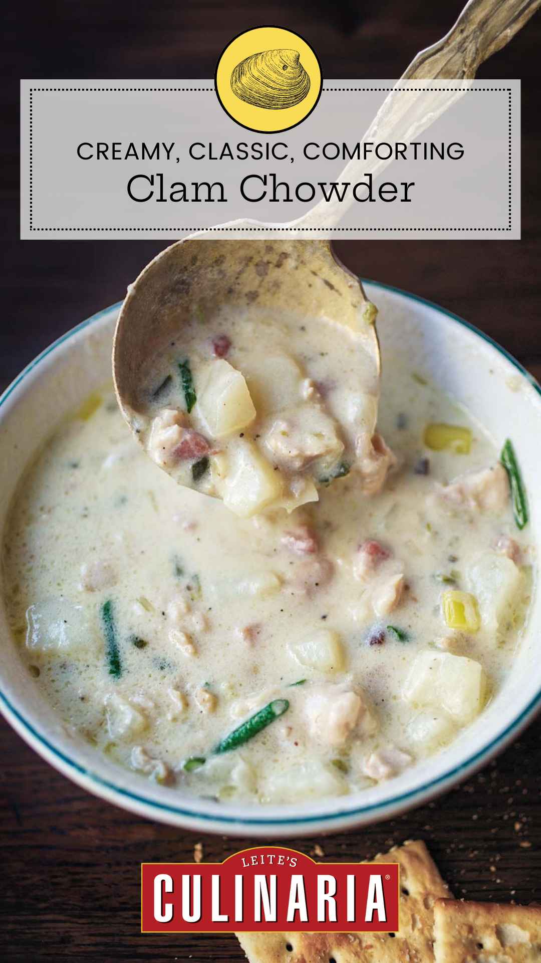 A bowl of New England clam chowder with a spoon scooping some out.