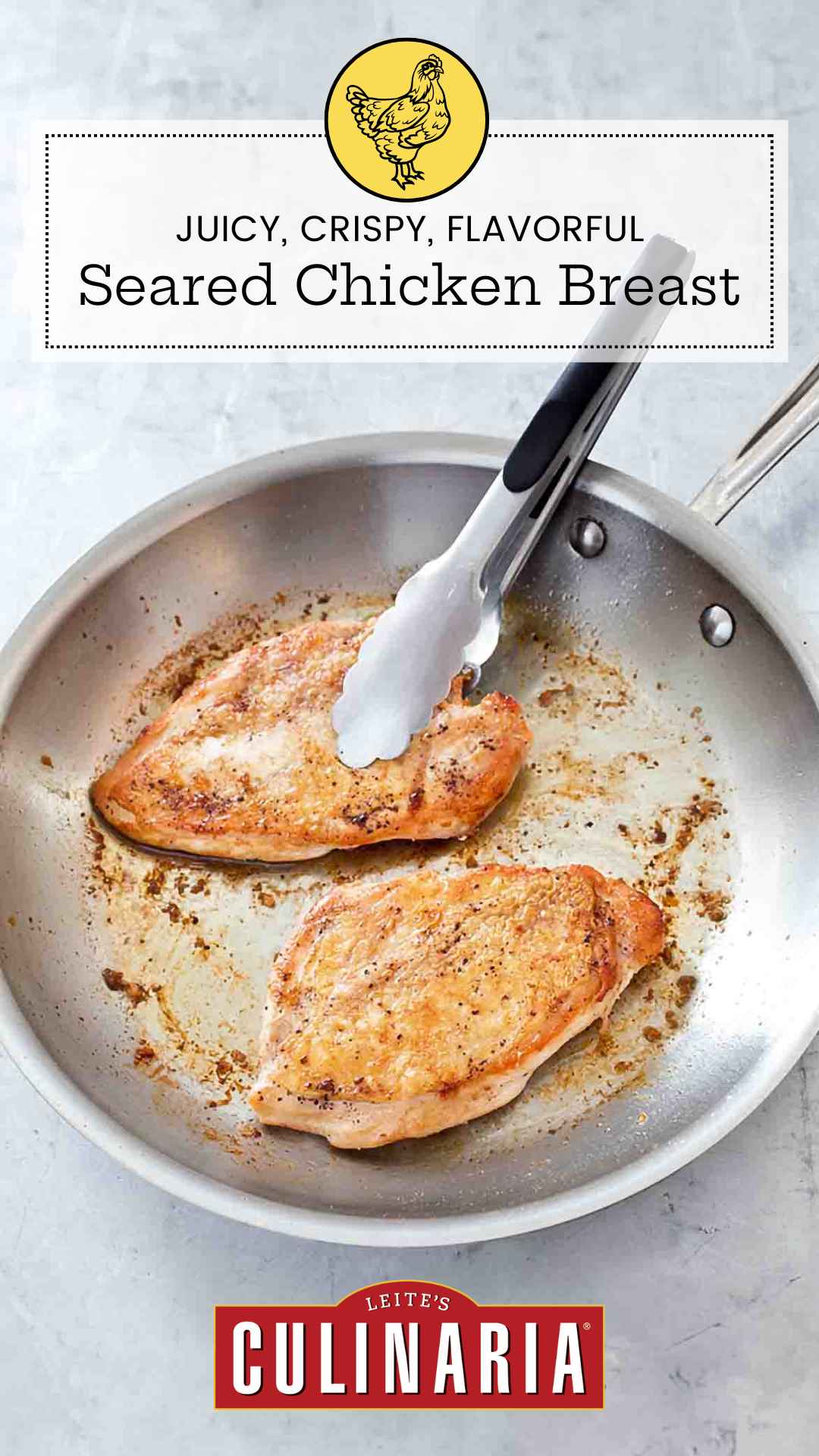 Two crispy pan seared chicken breasts in a metal skillet with a set of tongs.