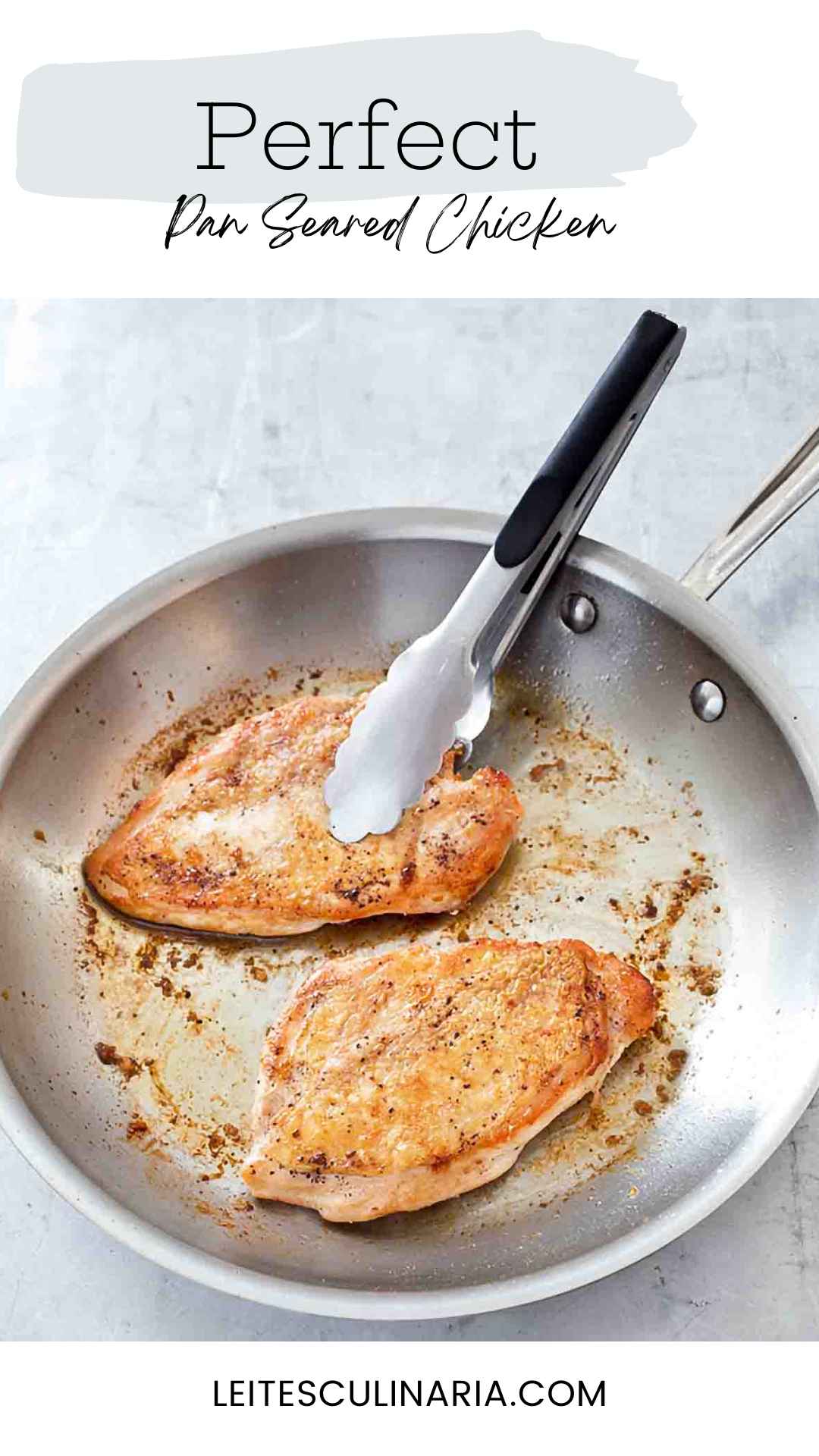 Two crispy pan seared chicken breasts in a metal skillet with a set of tongs.