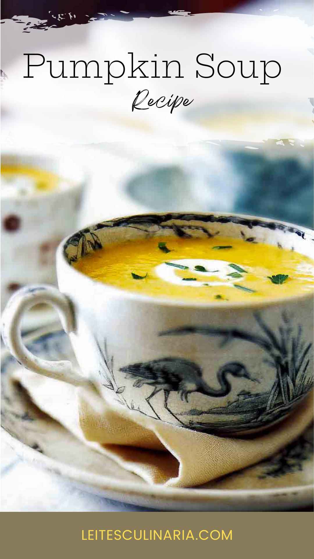 A large teacup filled with pumpkin cider soup with a swirl of creme fraiche and some herbs sprinkled on top.