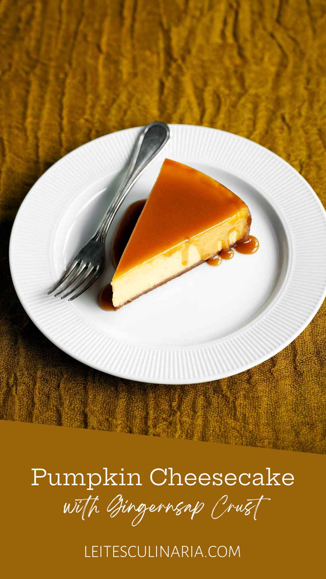 A slice of pumpkin cheesecake with caramel glaze drizzled over the top on a white plate with a fork on the side.