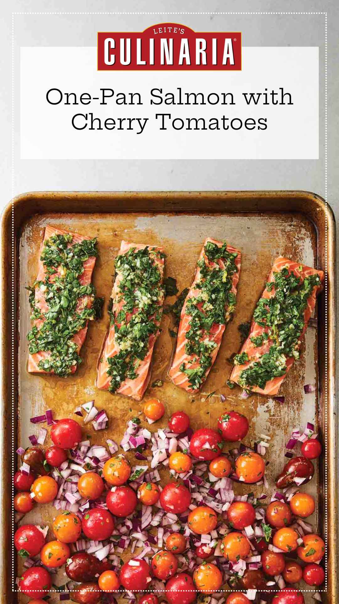 A baking sheet with four filets of salmon topped with a herb mixture, and a mixture of cherry tomatoes and red onion on the rest of the sheet.