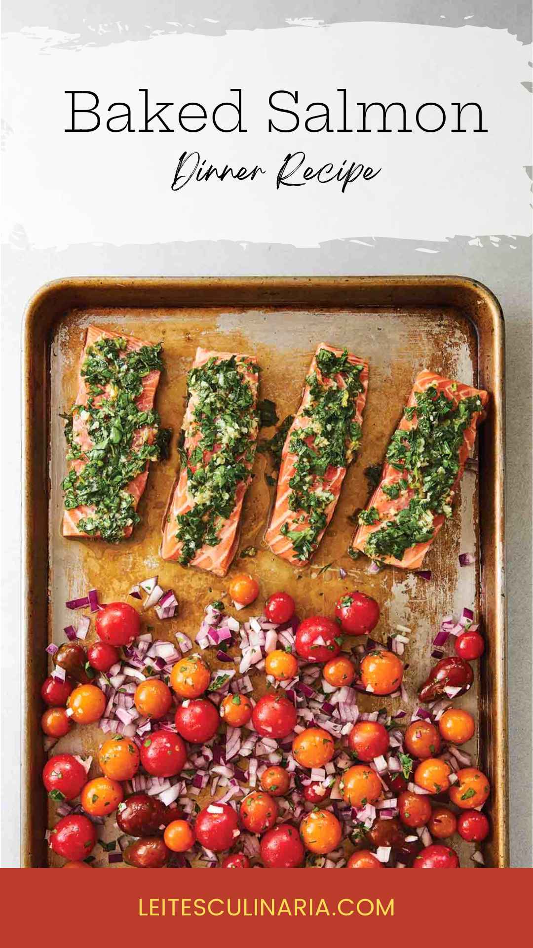 A baking sheet with four filets of salmon topped with a herb mixture, and a mixture of cherry tomatoes and red onion on the rest of the sheet.