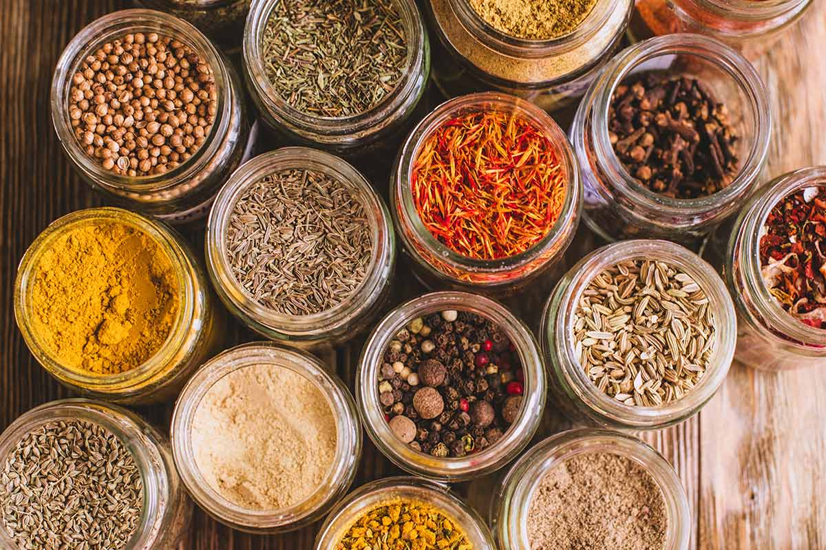 A collection of bottles filled with dried herbs and spices.