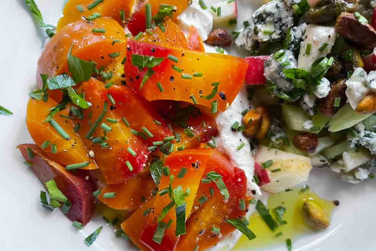 A golden beet salad sitting on top of whipped feta.