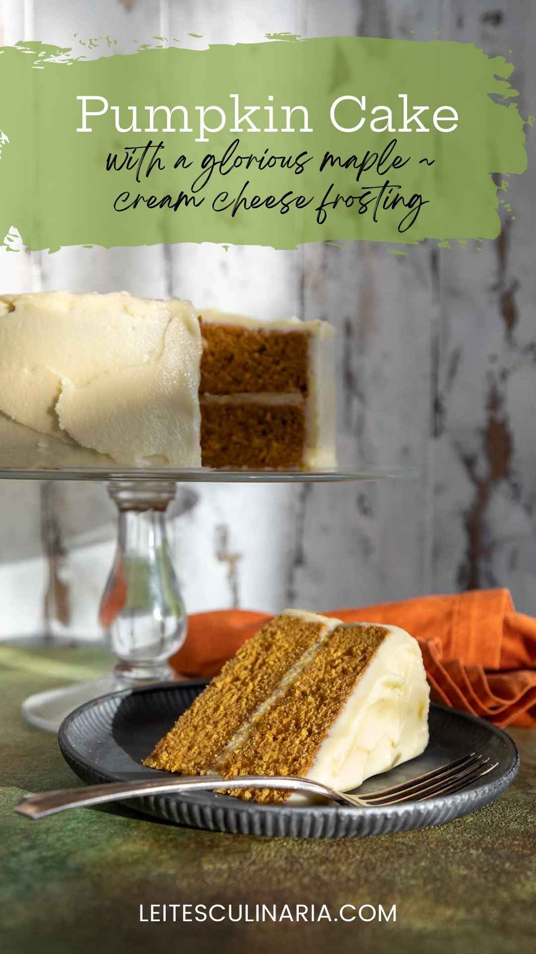 A slice of frosted pumpkin cake on a plate with the remaining cake on a stand in the background.