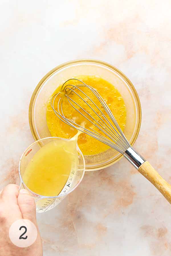 Lemon juice being poured into a bowl of Meijer lemon curd base.