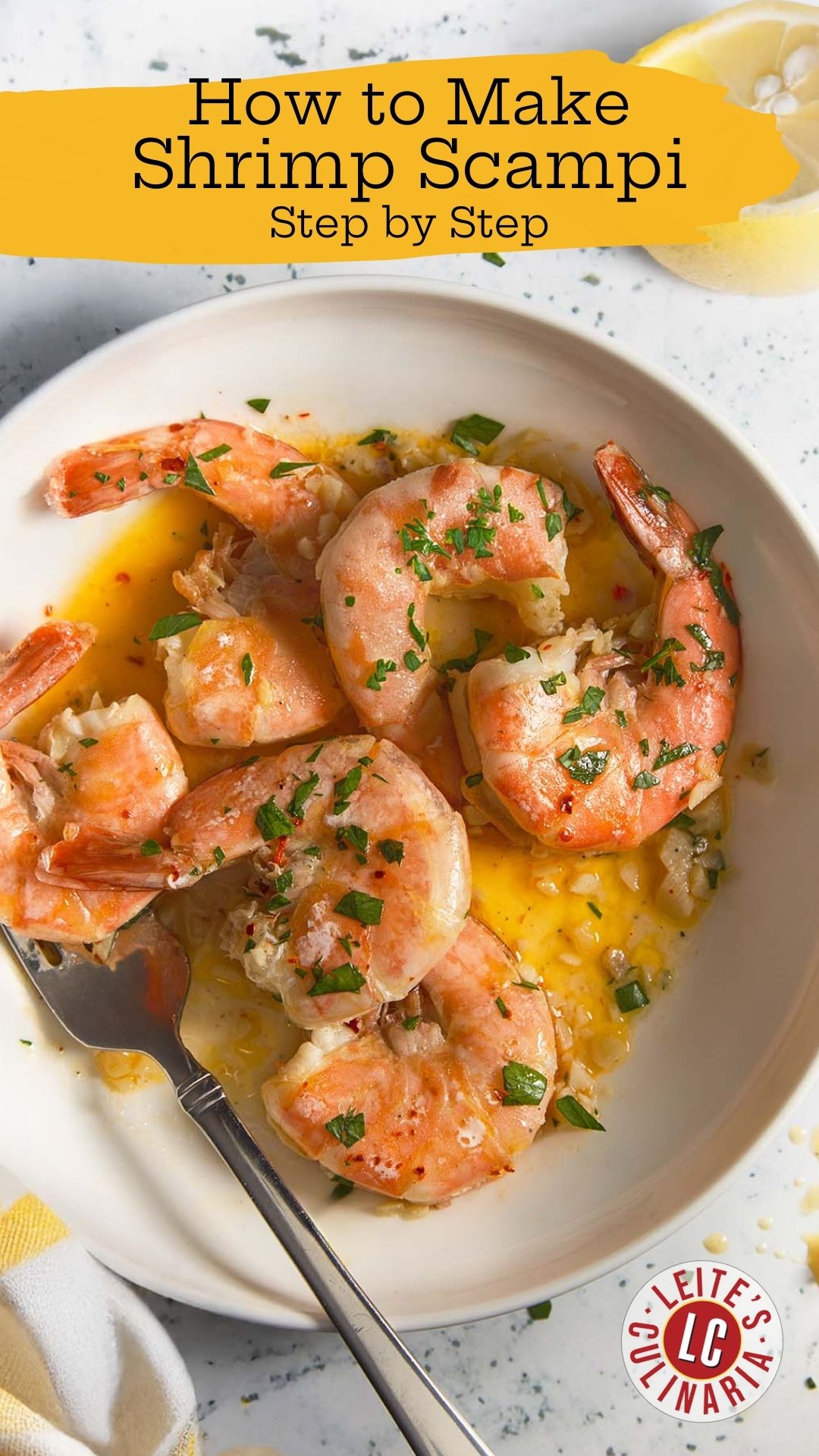 Overhead shot of shrimp scampi with golden garlic butter sauce, garnished with parsley, alongside a lemon wedge.